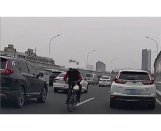男子骑自行车在高架车流中逆行，交警：发现此类行为可立即拨打122报警